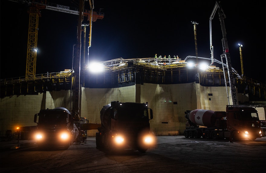 Trucks continue to assemble on the base of the east berm after dark.