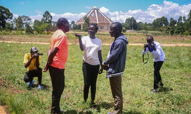 The radio Jamii team records an interview on the temple grounds in Matunda.